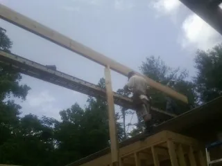 Carpenter setting a ridge beam over a new addition frame — Ice Dam Removal by Roofing Brothers in Cypress Inn