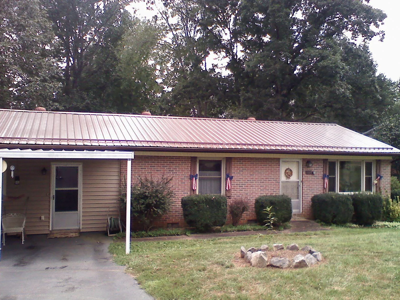 Bronze metal roof and carport on a brick ranch home — Roof Repair work by our crew in Cypress Inn